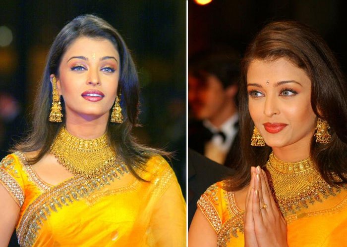 Aishwarya in an eye-catching, bright mustard yellow and gold saree with heavy gold jewelry - in 2002