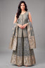 Woman wearing a traditional outfit with a gray and gold color scheme on a gray background