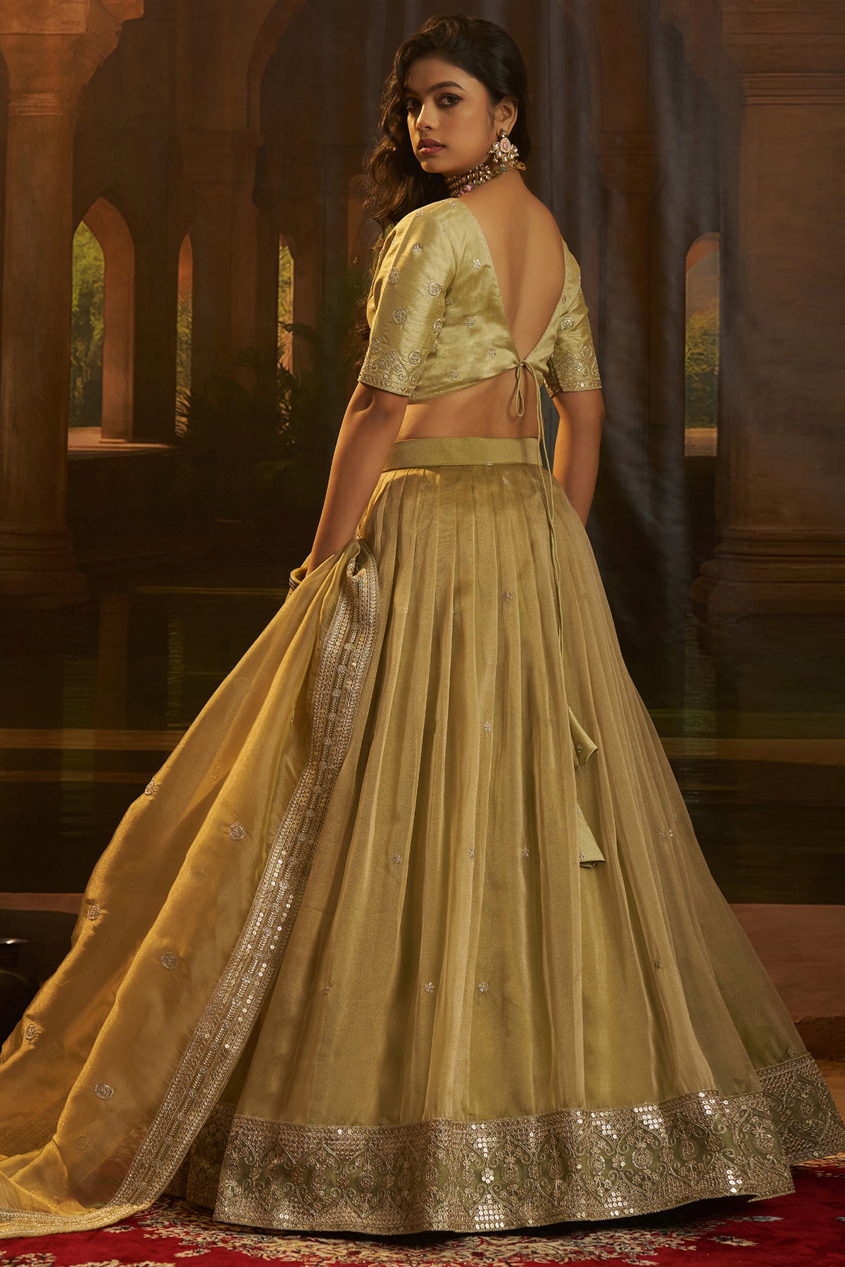 Muted Pistachio Gold Crepe Lehenga with Sequins Border featuring intricate golden patterns