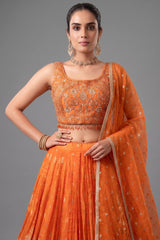 Close up details of orange organza woven pleated lehenga fabric