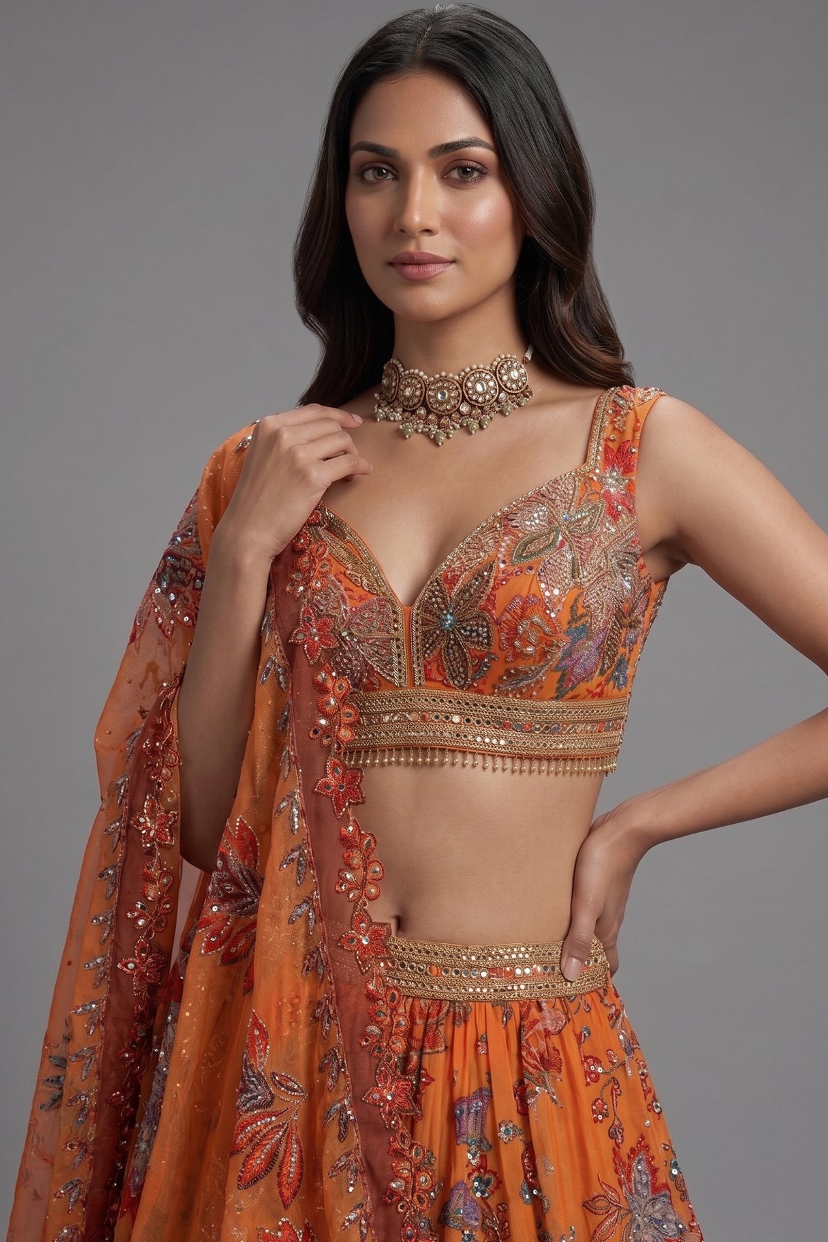 Close up of gold sequins and metallic cutdana work on Orange Organza Lehenga