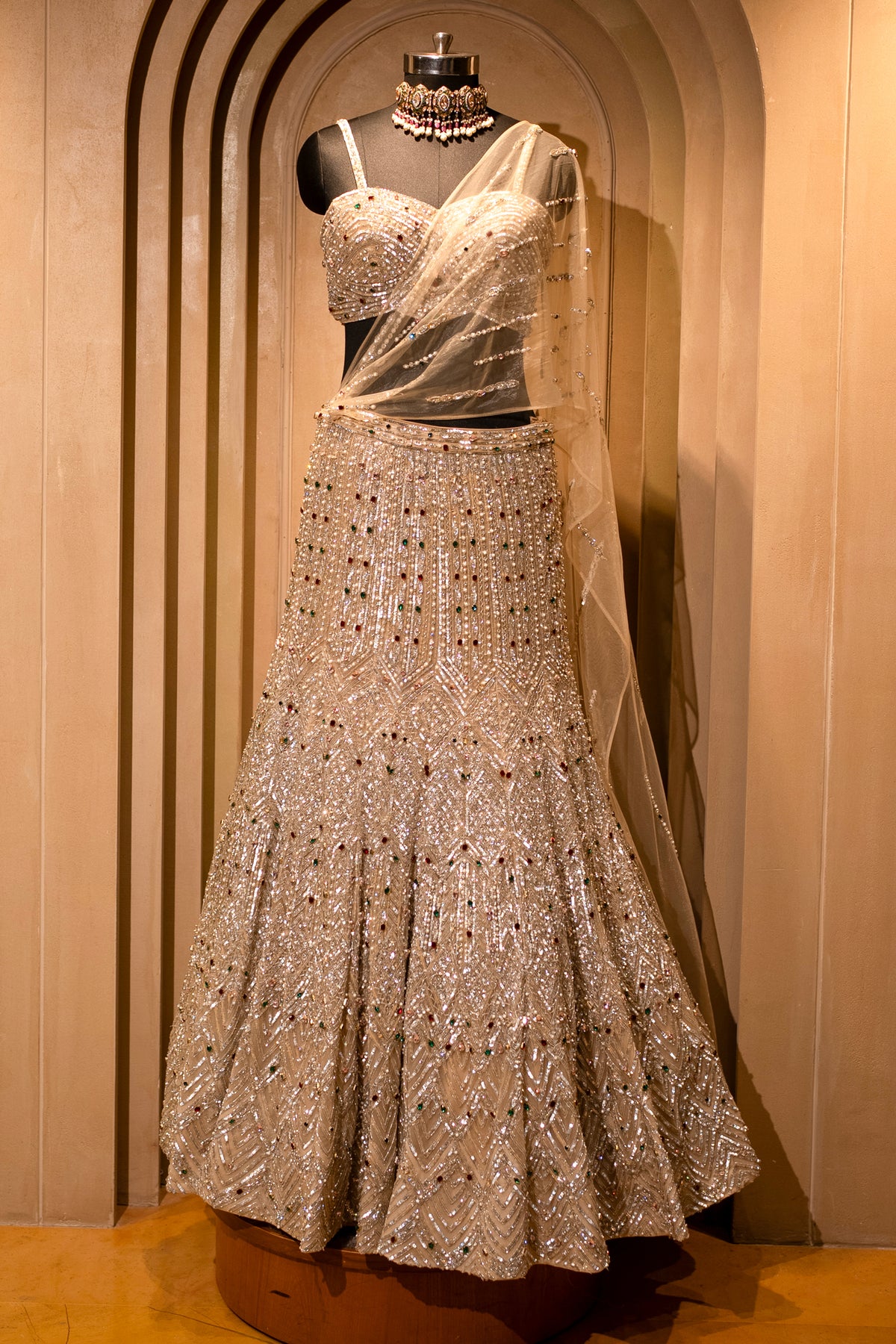 Attached cape-style dupatta details on the Champagne Gold Net Mermaid Lehenga