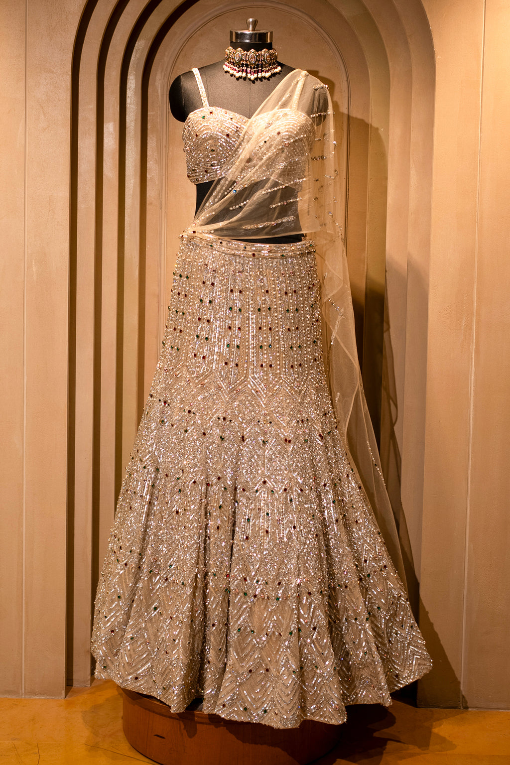 Attached cape-style dupatta details on the Champagne Gold Net Mermaid Lehenga