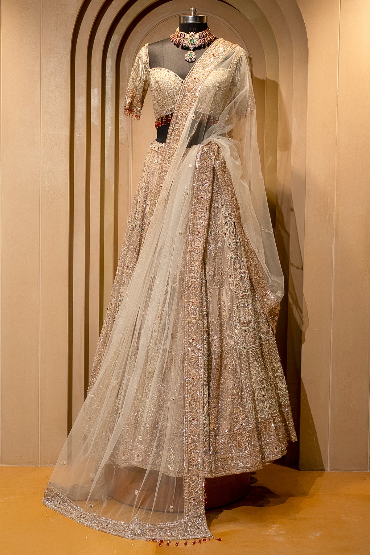 Close-up of luminescent stone-craft on the Beige Net Bridal Lehenga