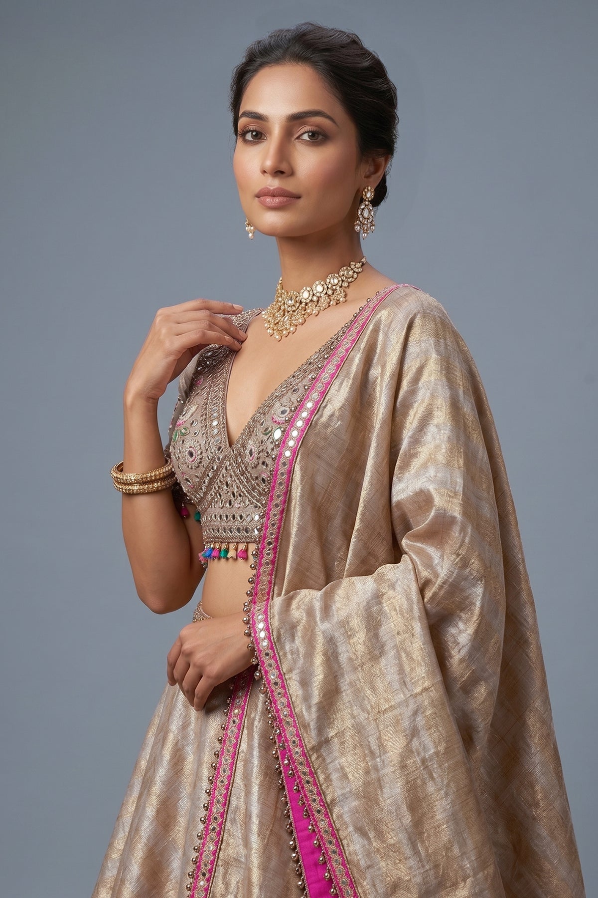 Golden Tissue Silk Lehenga showcasing close up of emerald and ruby stone work embroidery