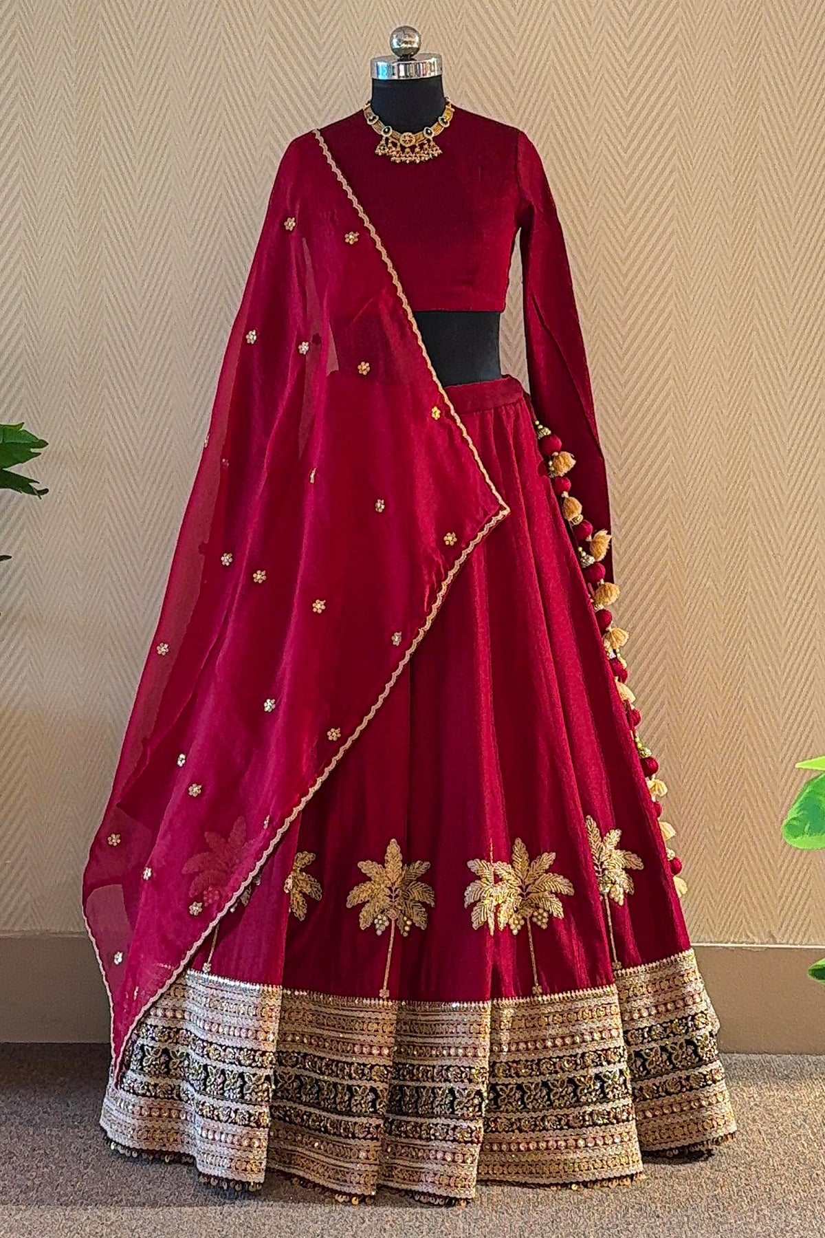Intricate palm tree motifs on the skirt of the Maroon Matka Silk Bridal Lehenga