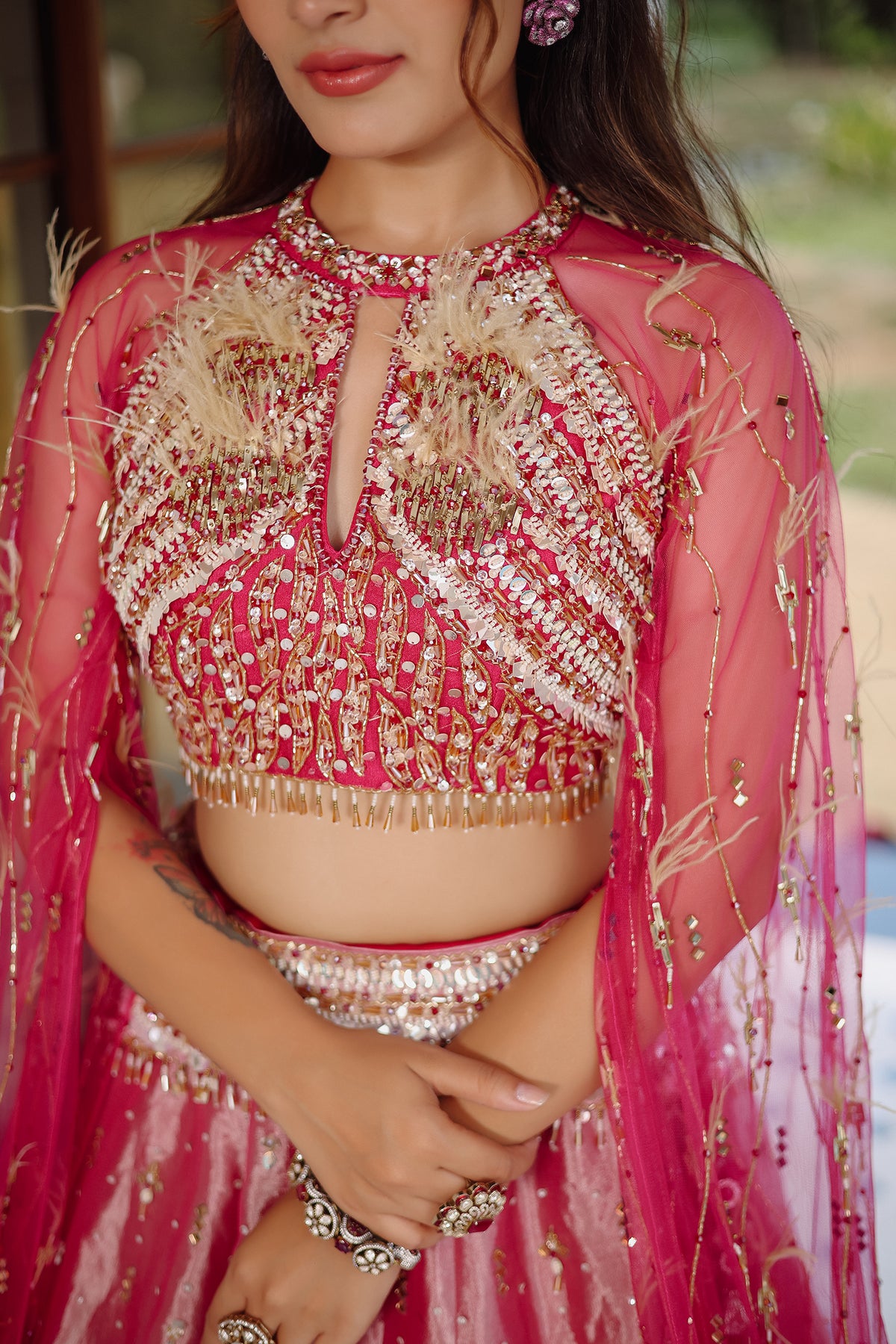 The Fuchsia Pink Ombre Tissue Lehenga Ensemble with High-Neck Keyhole Blouse and Floor-Length Feather Cape Sleeves