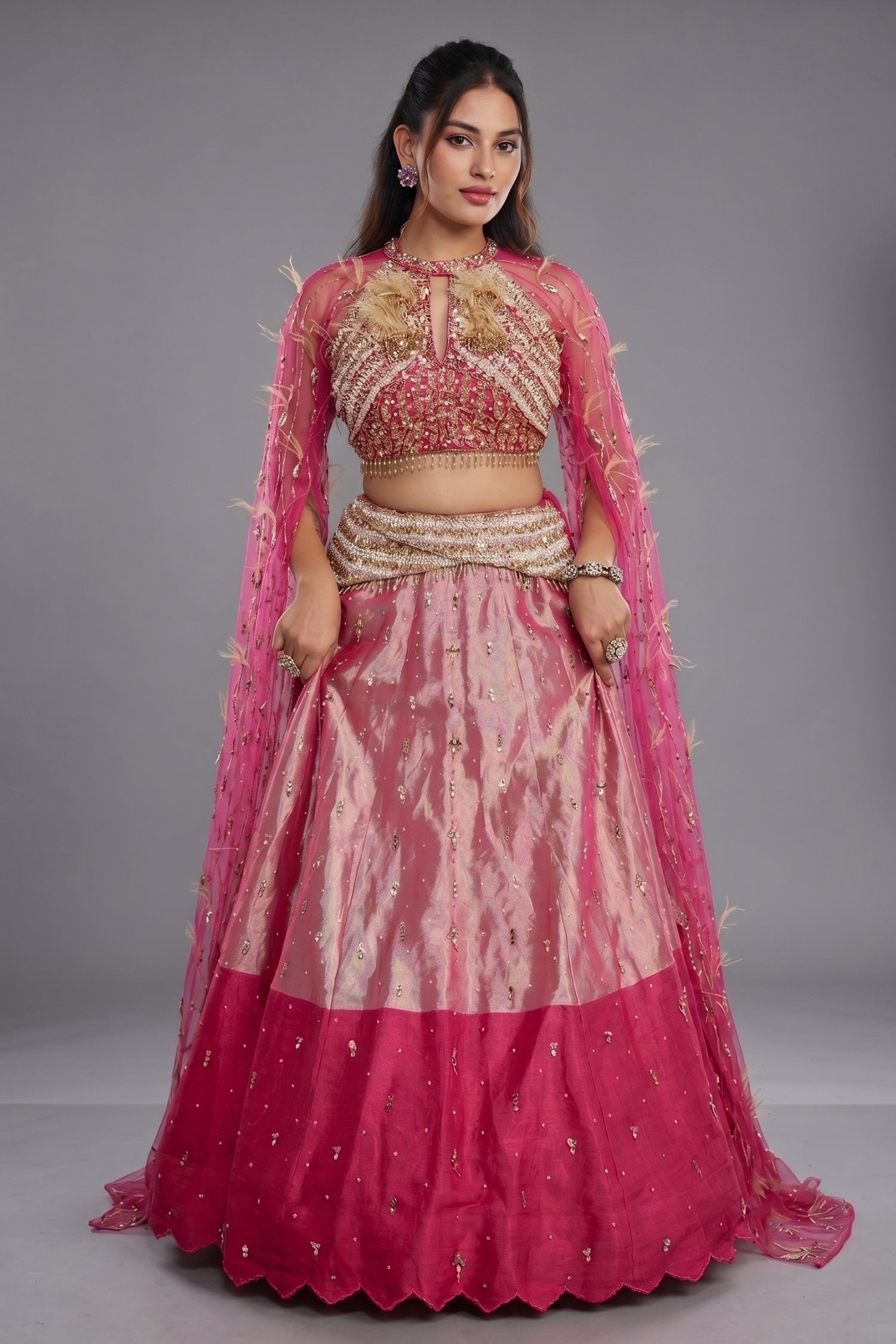 The Fuchsia Pink Ombre Tissue Lehenga Ensemble with High-Neck Keyhole Blouse and Floor-Length Feather Cape Sleeves Main image