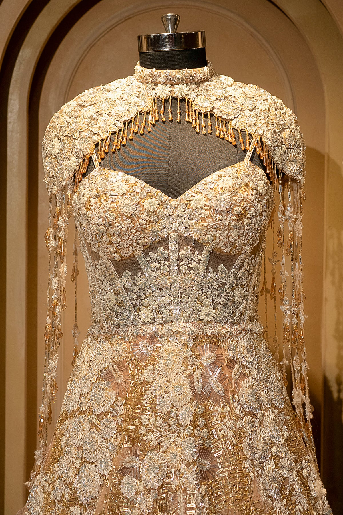 Plunging V-neckline and bodice details of the Champagne Gold Net Couture Gown