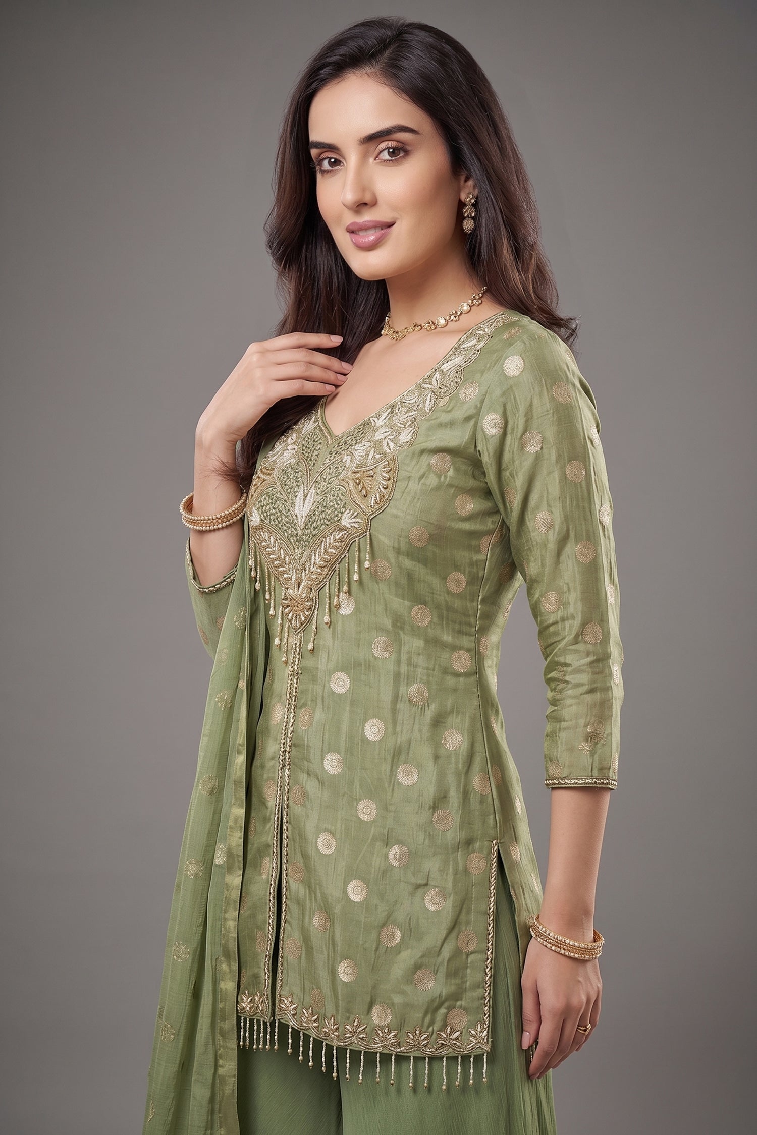 Close up of Pista Green Chinon Silk Woven and Mirror Worked Palazzo Suit showing Gold Butti Weaving