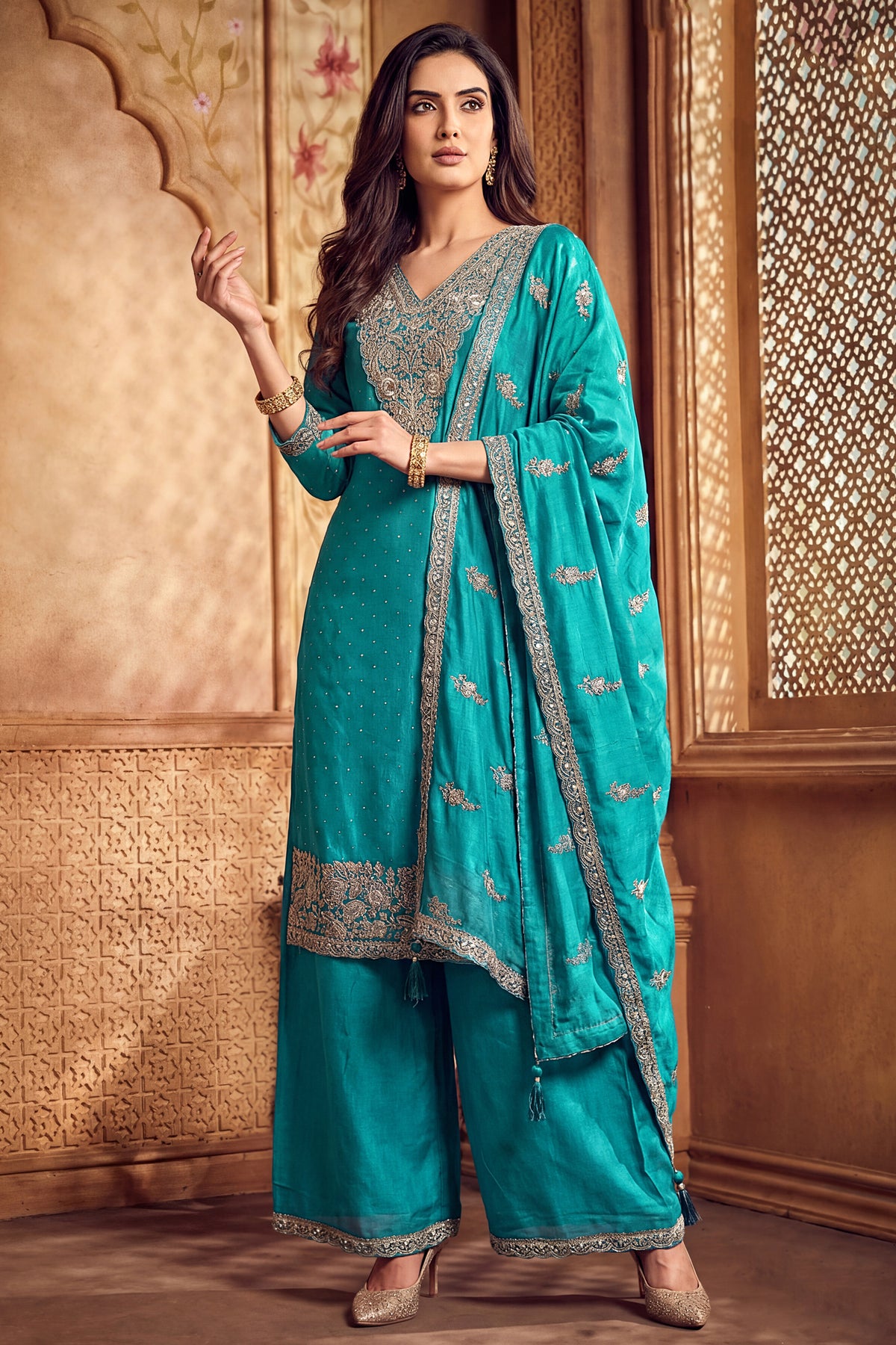 Model wearing turquoise blue art silk palazzo suit with scalloped dupatta