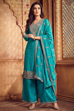 Model wearing turquoise blue art silk palazzo suit with scalloped dupatta
