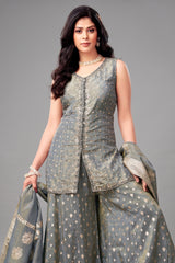 Woman wearing a traditional outfit with a gray top and skirt on a gray background